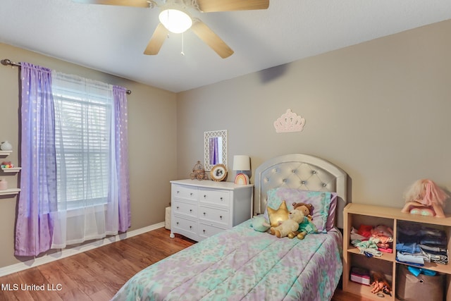 bedroom with a ceiling fan, wood finished floors, and baseboards