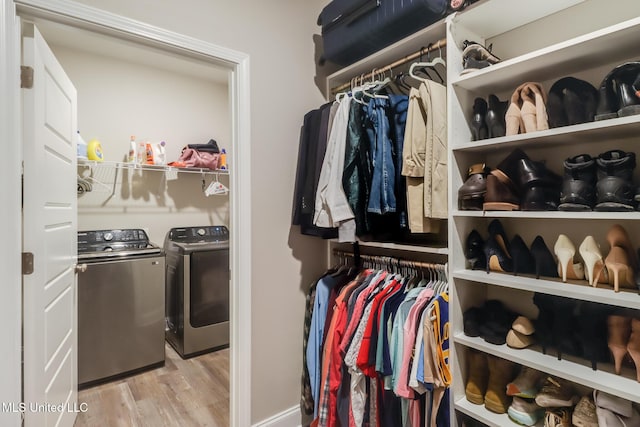 87139 Highpoint Dr, Diamondhead, MS 39525 - walk in closet featuring separate washer and dryer and light wood-style floors
