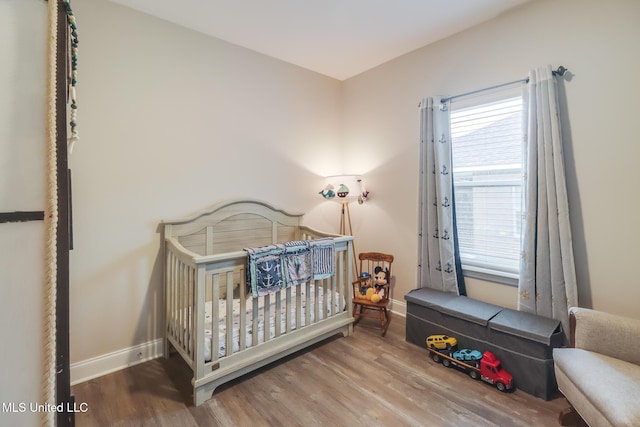 87139 Highpoint Dr, Diamondhead, MS 39525 - bedroom featuring wood finished floors, multiple windows, and a nursery area