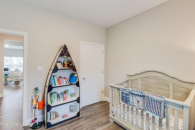 87139 Highpoint Dr, Diamondhead, MS 39525 - bedroom with wood finished floors and a nursery area
