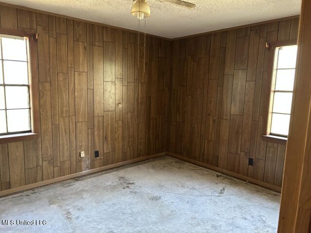 2728 Dogwood Ln, Moss Point, MS 39562 - unfurnished room with wooden walls, a textured ceiling, and concrete floors