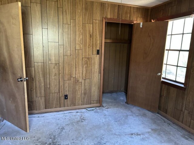 2728 Dogwood Ln, Moss Point, MS 39562 - unfurnished bedroom featuring wooden walls and unfinished concrete flooring