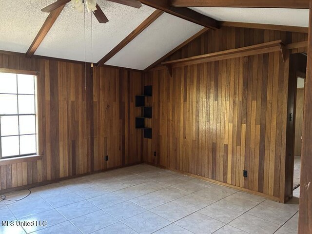 2728 Dogwood Ln, Moss Point, MS 39562 - empty room with lofted ceiling with beams, a textured ceiling, ceiling fan, and wood walls