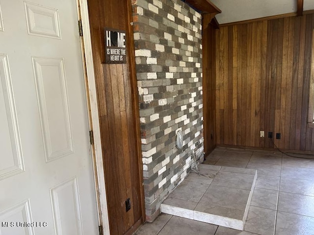 2728 Dogwood Ln, Moss Point, MS 39562 - hallway with tile patterned floors, wood walls, and brick wall