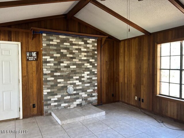 2728 Dogwood Ln, Moss Point, MS 39562 - tiled empty room with lofted ceiling with beams, wooden walls, and a textured ceiling