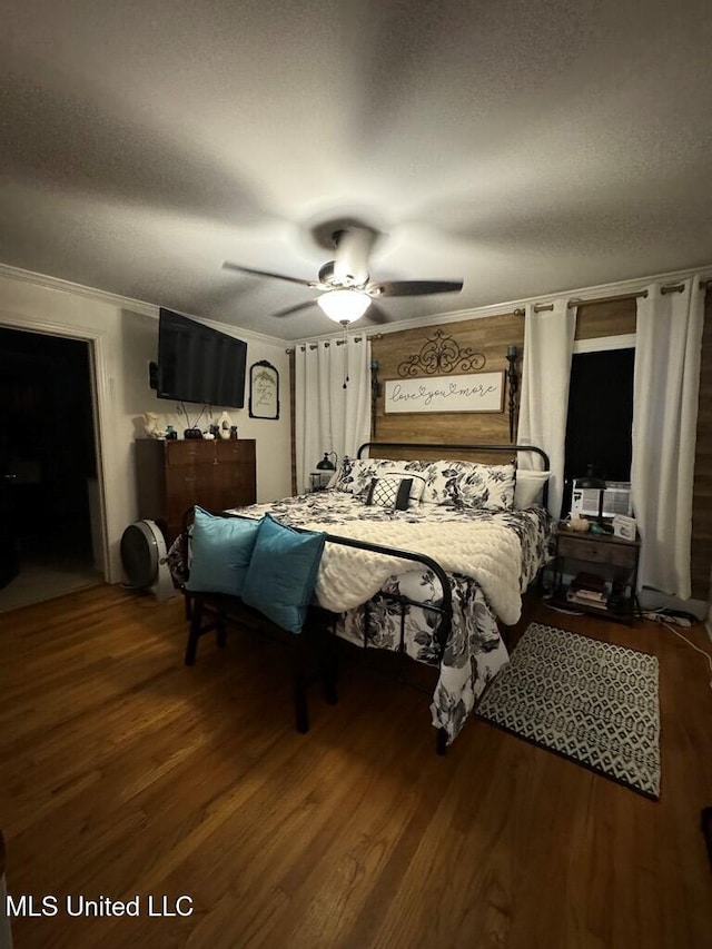 bedroom with ceiling fan, wood-type flooring, a textured ceiling, and ornamental molding