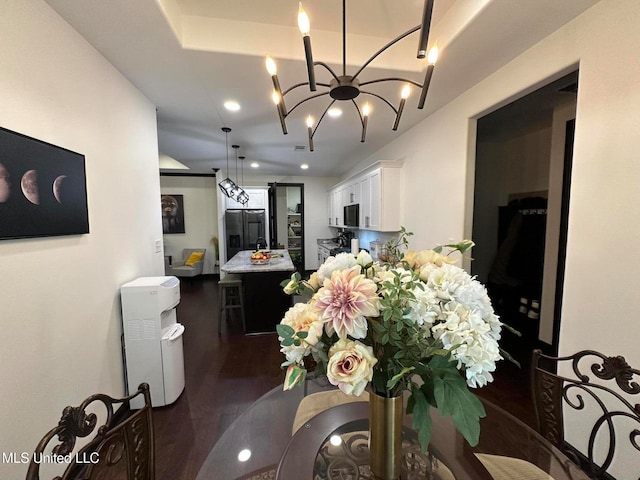 dining area featuring a notable chandelier and dark hardwood / wood-style flooring