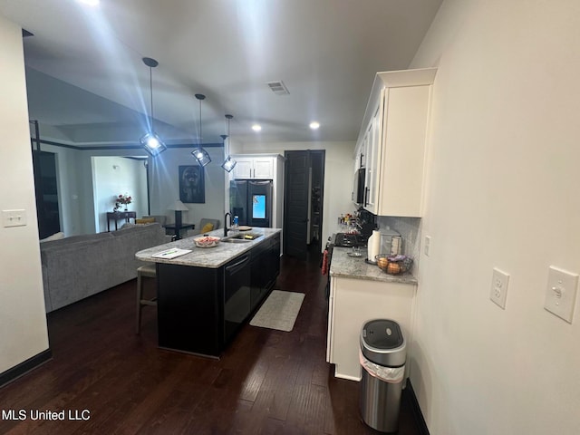 kitchen with dark wood-type flooring, a kitchen island with sink, white cabinets, sink, and fridge