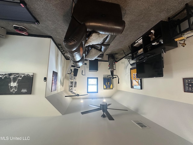 living room with ceiling fan and a textured ceiling