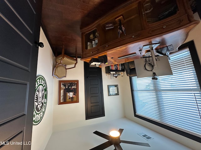 interior space featuring ceiling fan and wooden ceiling