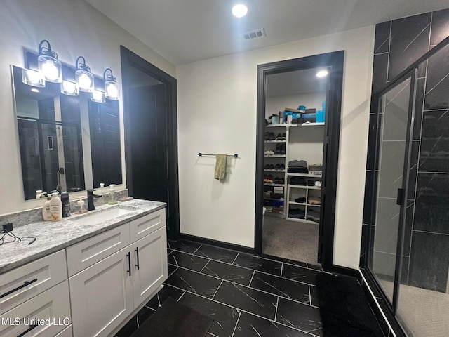 bathroom featuring tile patterned flooring, vanity, and a shower with shower door