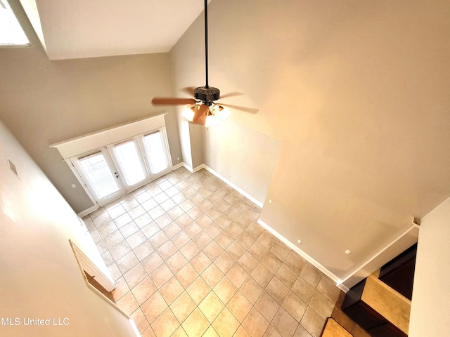 unfurnished living room featuring ceiling fan, french doors, and light tile patterned floors