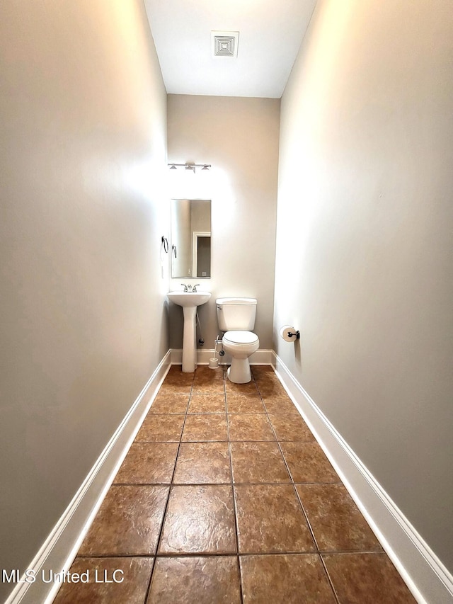 bathroom featuring toilet, tile patterned floors, and sink