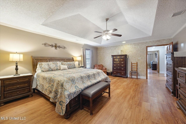 bedroom featuring a raised ceiling, ceiling fan, ornamental molding, a textured ceiling, and light hardwood / wood-style floors