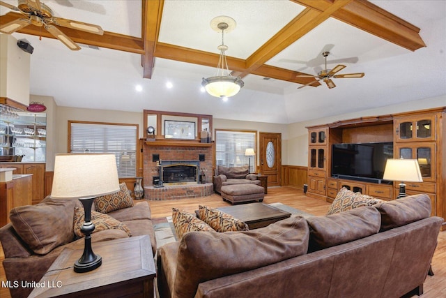 living room featuring beamed ceiling, light wood-type flooring, a fireplace, and coffered ceiling