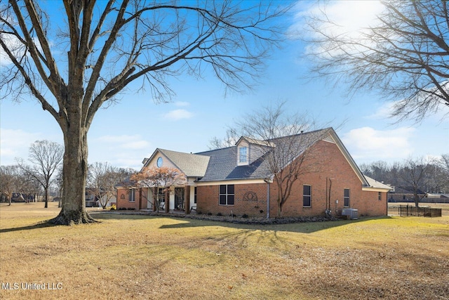 cape cod house featuring central AC unit and a front lawn