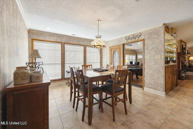 tiled dining space featuring ornamental molding, a textured ceiling, and a chandelier