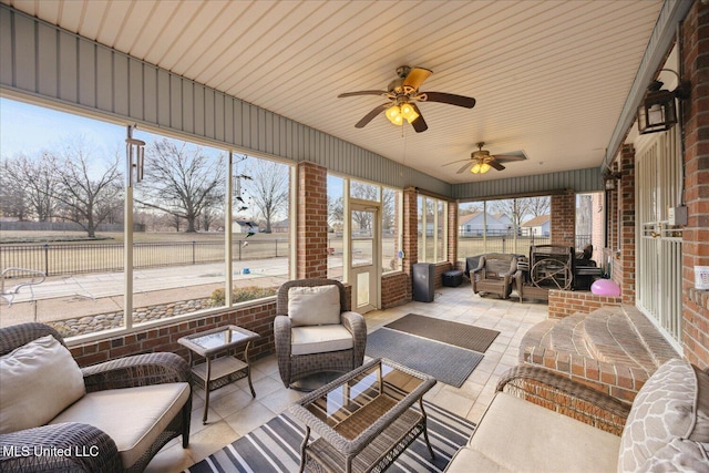 sunroom featuring a rural view and ceiling fan