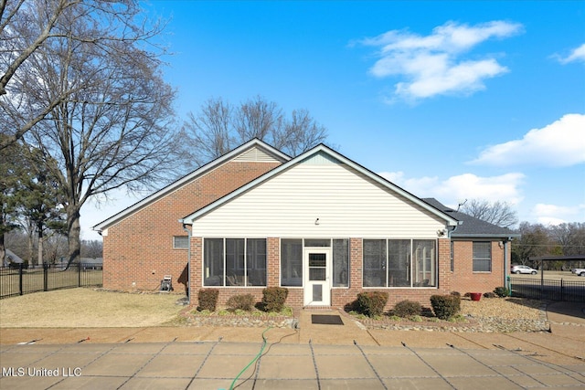 rear view of property with a sunroom and a patio area