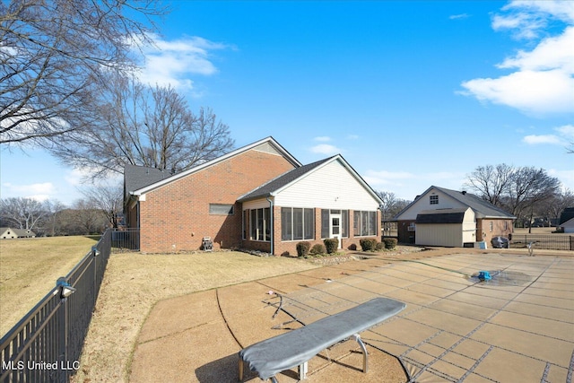 rear view of house with an outbuilding, a covered pool, and a patio area