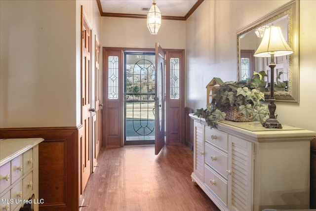 entrance foyer featuring crown molding and light wood-type flooring