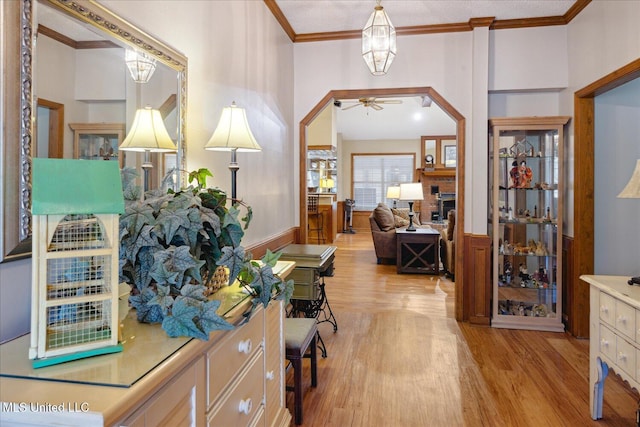 home office with light wood-type flooring, ceiling fan, and ornamental molding