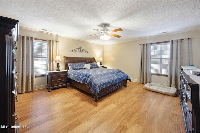 bedroom with ceiling fan, crown molding, a textured ceiling, and light hardwood / wood-style flooring