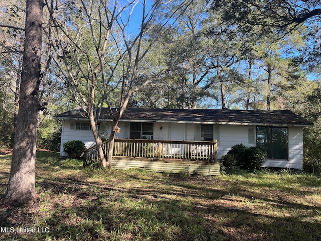 view of front facade featuring a wooden deck and a front yard