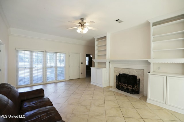 living room featuring light tile patterned floors, a high end fireplace, and ceiling fan