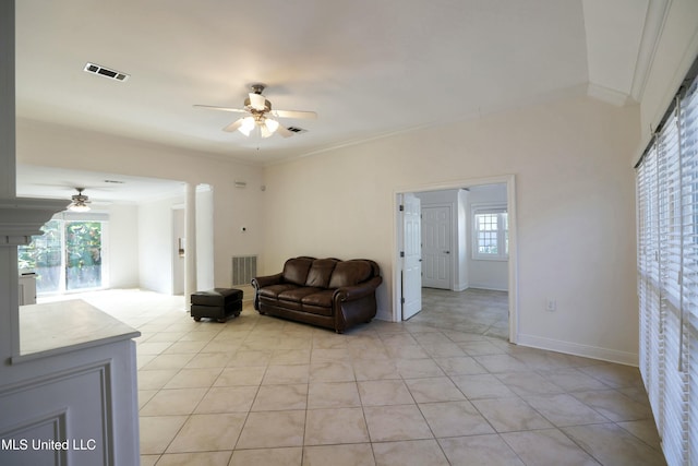 living room with light tile patterned floors, crown molding, and ceiling fan