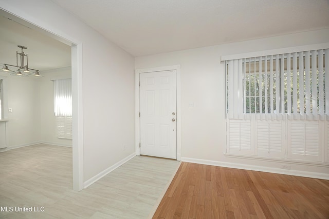 entrance foyer with baseboards and wood finished floors