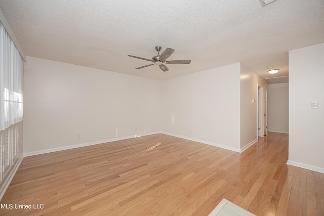 unfurnished room with a textured ceiling, light wood-type flooring, and a ceiling fan