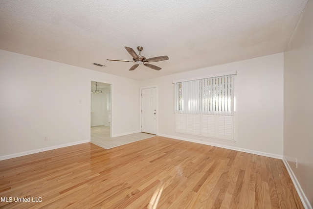 spare room featuring a textured ceiling, ceiling fan, and light wood-style floors