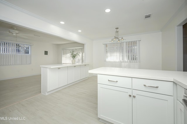 kitchen with light wood-style flooring, ornamental molding, a peninsula, light countertops, and recessed lighting