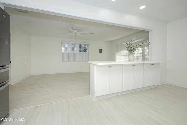 kitchen with light wood-style flooring, baseboards, ceiling fan, and freestanding refrigerator