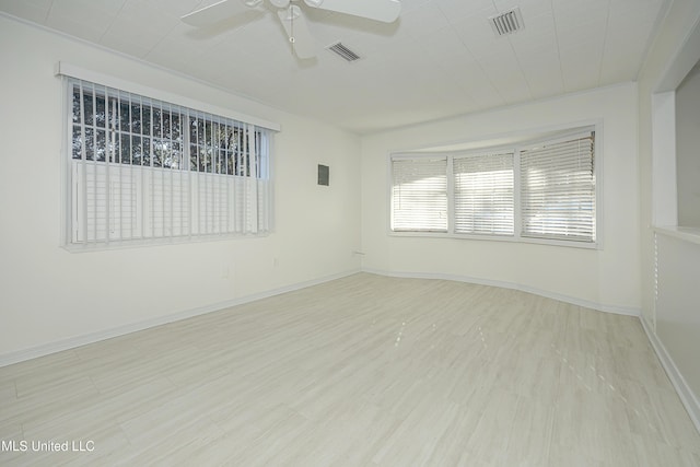 unfurnished room with a ceiling fan, light wood-type flooring, visible vents, and baseboards