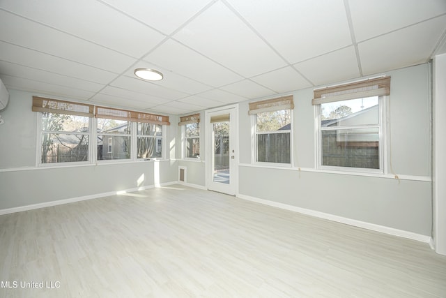 unfurnished sunroom featuring a drop ceiling