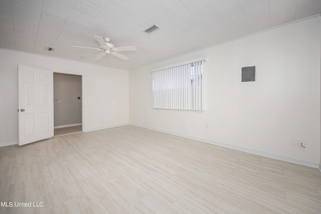 spare room with light wood-style floors, visible vents, baseboards, and a ceiling fan