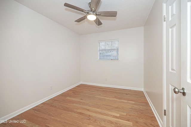 spare room with light wood-type flooring, ceiling fan, baseboards, and a textured ceiling