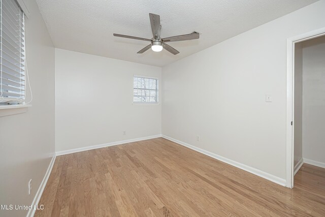 unfurnished room featuring a textured ceiling, a ceiling fan, light wood-style flooring, and baseboards