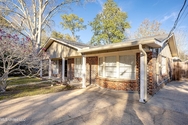 single story home with board and batten siding, brick siding, and fence