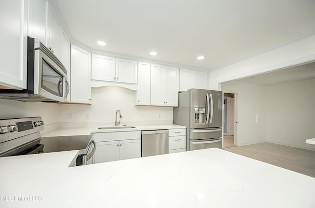 kitchen featuring stainless steel appliances, recessed lighting, white cabinets, and a sink