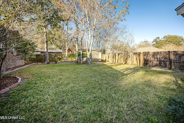 view of yard with an outbuilding, a shed, and a fenced backyard