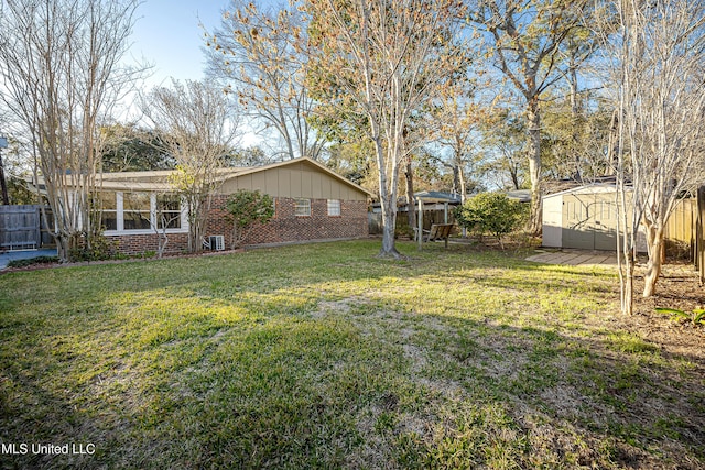 view of yard featuring a fenced backyard, a storage unit, and an outbuilding