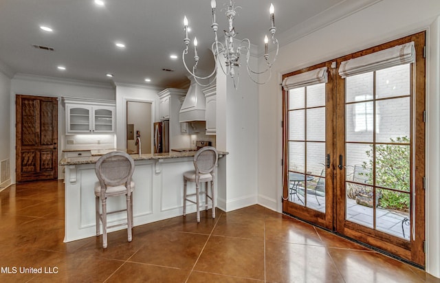 kitchen with kitchen peninsula, white cabinets, french doors, and crown molding