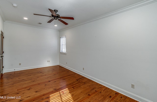 empty room featuring ceiling fan, crown molding, and hardwood / wood-style flooring