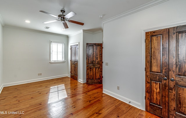 unfurnished bedroom with ceiling fan, wood-type flooring, and crown molding