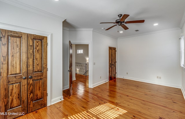 empty room featuring ceiling fan, crown molding, and light hardwood / wood-style floors