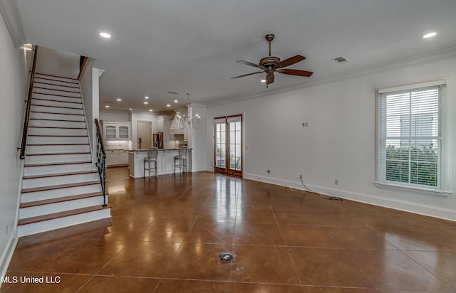 unfurnished living room with ceiling fan, dark tile patterned flooring, and crown molding