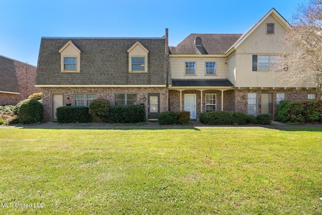 multi unit property featuring a front yard, brick siding, and roof with shingles